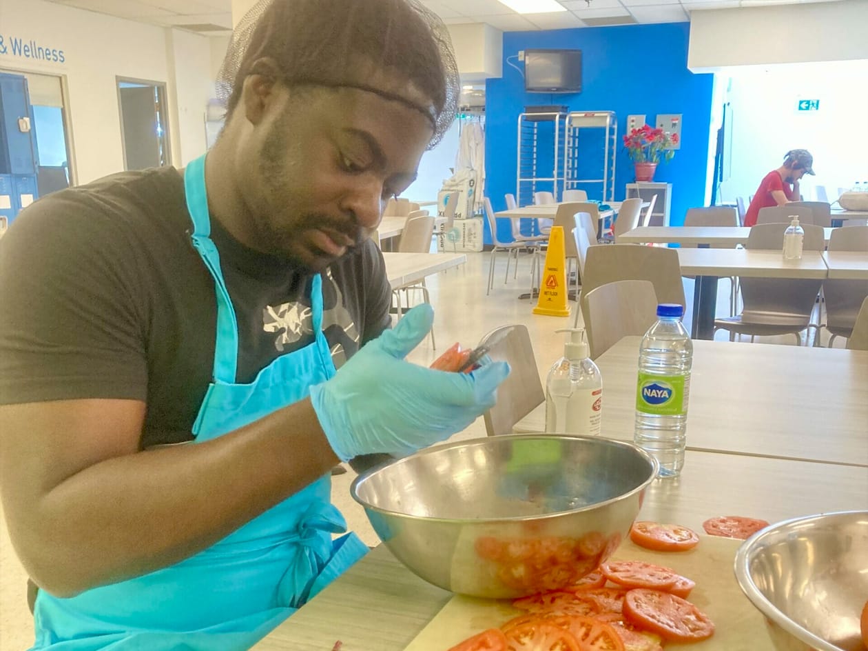 Man cutting tomatoes at Progress Place